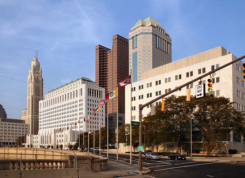 a photo of columbus street and a green light allowing cars to pass thru