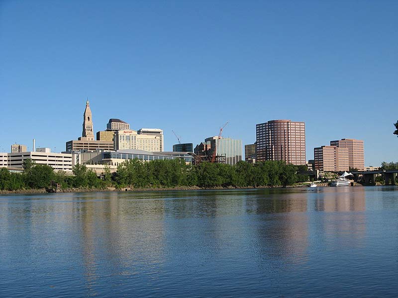 a photo of a river and hartford skyline on a sunny day