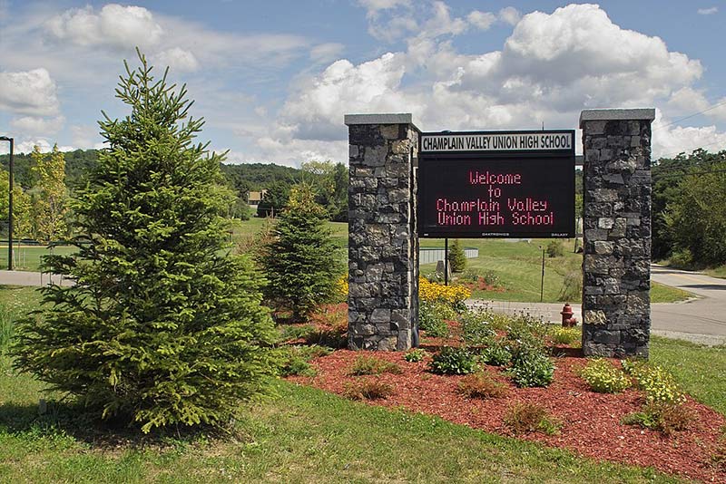 a welcome to high school sign in a green area