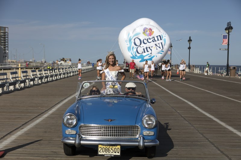 miss new jersey riding in a blue convertible as a part of a parade