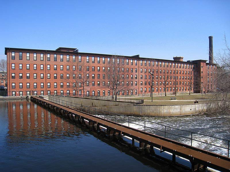 a bridge leading to a huge red brick manufacturing complex